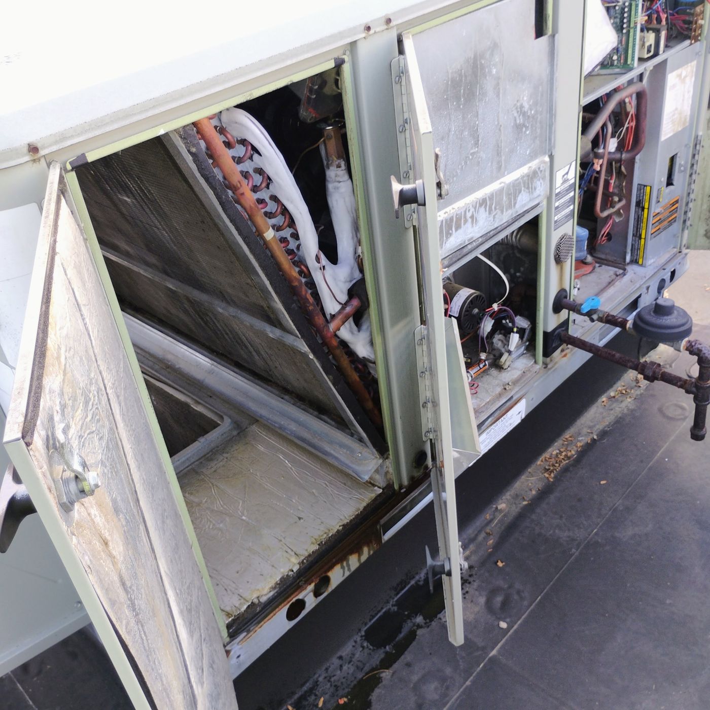 Open commercial rooftop HVAC unit during professional maintenance service