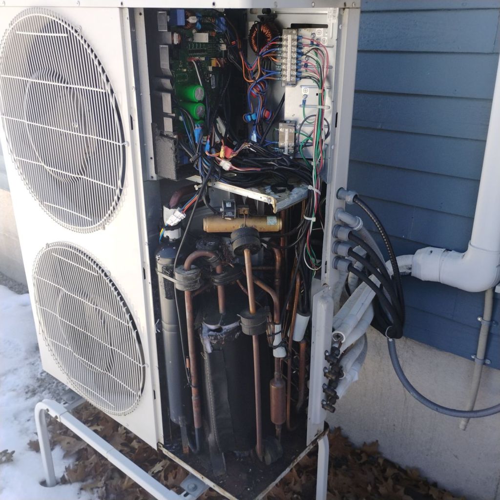 Open residential heat pump outdoor unit during professional diagnostic and repair service
