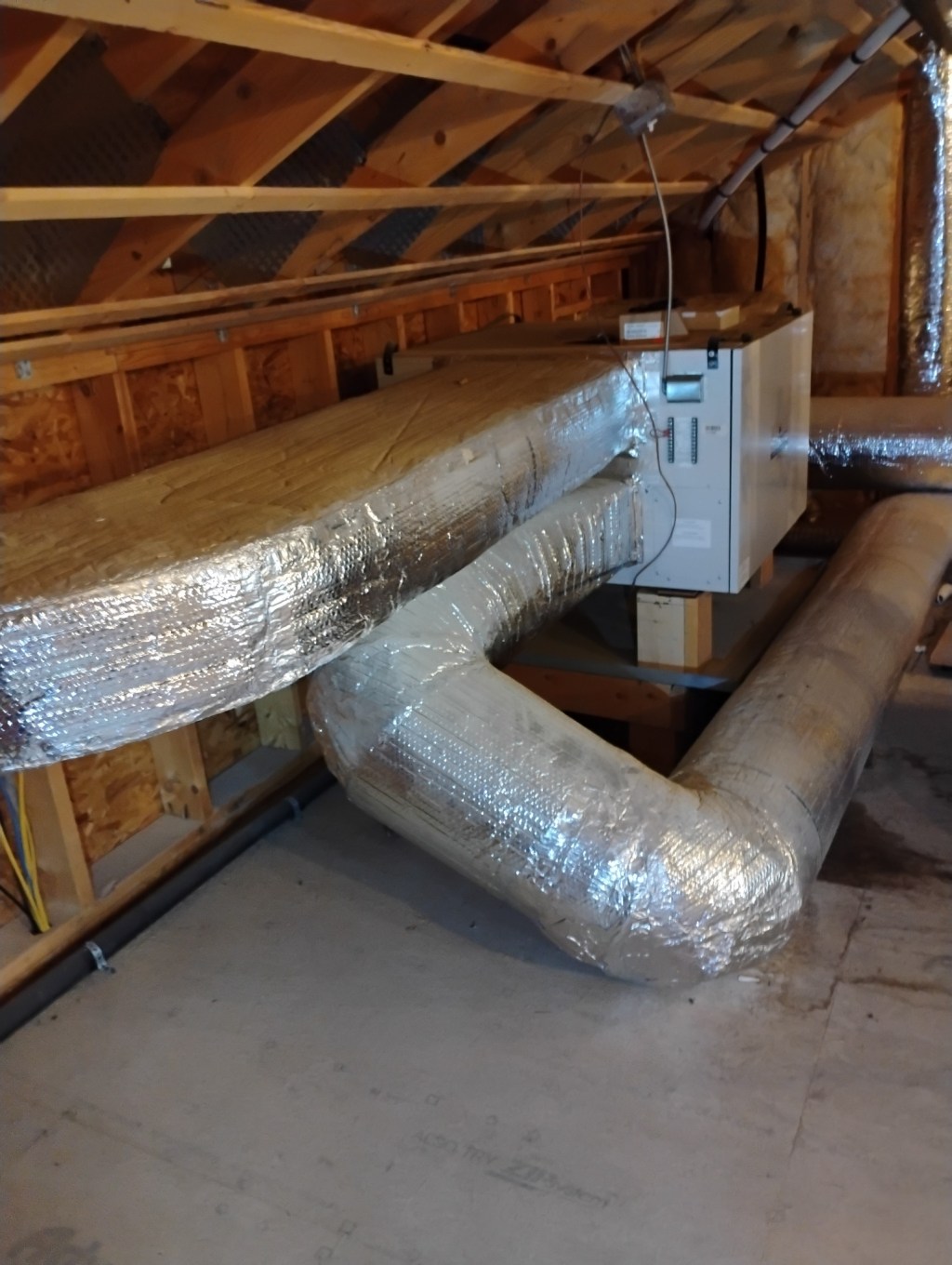 Residential heat recovery ventilator and insulated ductwork installed in an attic